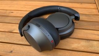 The 1More SonoFlow headphones sitting on a bench.