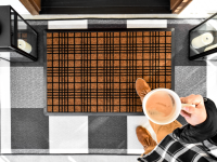 A person enters their home while stepping on a Ruggable welcome mat.