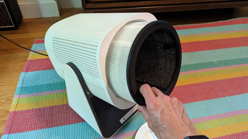 A person holding the Coway Airmega Aim air purifier.