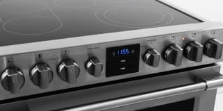 A close-up photo of an electric range highlighting the electric cooktop and the oven control knobs.