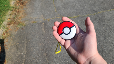 A person holding the Pokémon Go Plus +