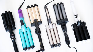 Six hair wavers lay in a row with the barrel ends facing the same direction every other waver.