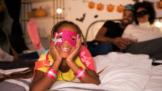 Little girl in costume on a bed