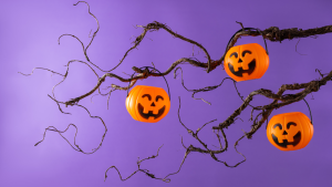 Stock image of a Halloween tree with gnarled limbs and pumpkin basket decorations.