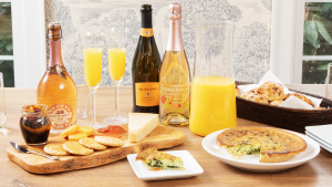 Spread of mimosas and brunch food on wooden table