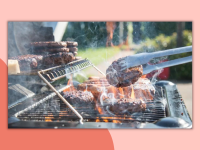 Several burgers cooking on a grill, shot from the side, with a pair of tongs holding a patty.