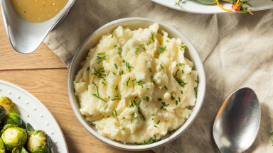 A bowl of mashed potatoes on a table, shot from above