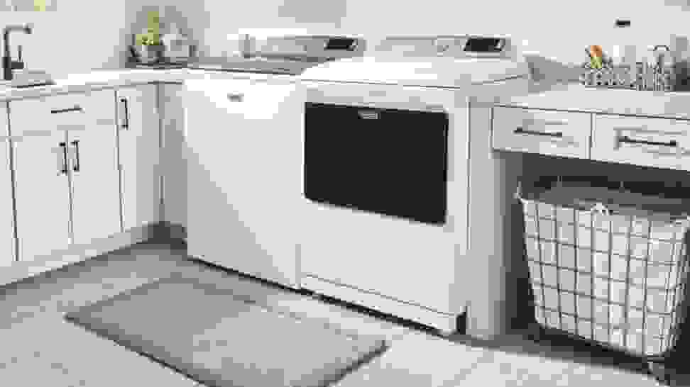 A white washing machine and dryer sit in a laundry room