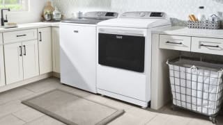 A white washing machine and dryer sit in a laundry room