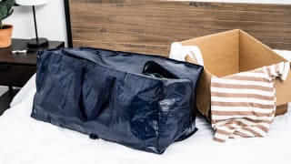 Blue vinyl moving bags next to a cardboard moving bag.