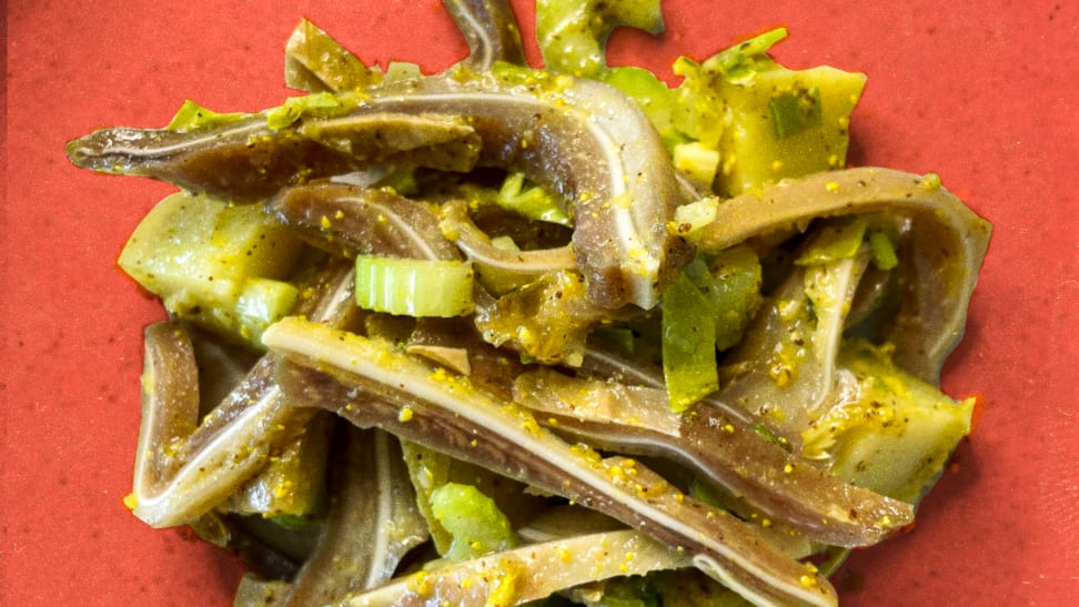 Pig ear potato salad on a red plate