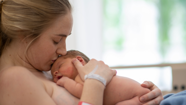 Woman kissing new baby