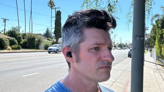 Angled shot of author John Higgins wearing a Sony WF-1000XM5 earbud in his right ear.